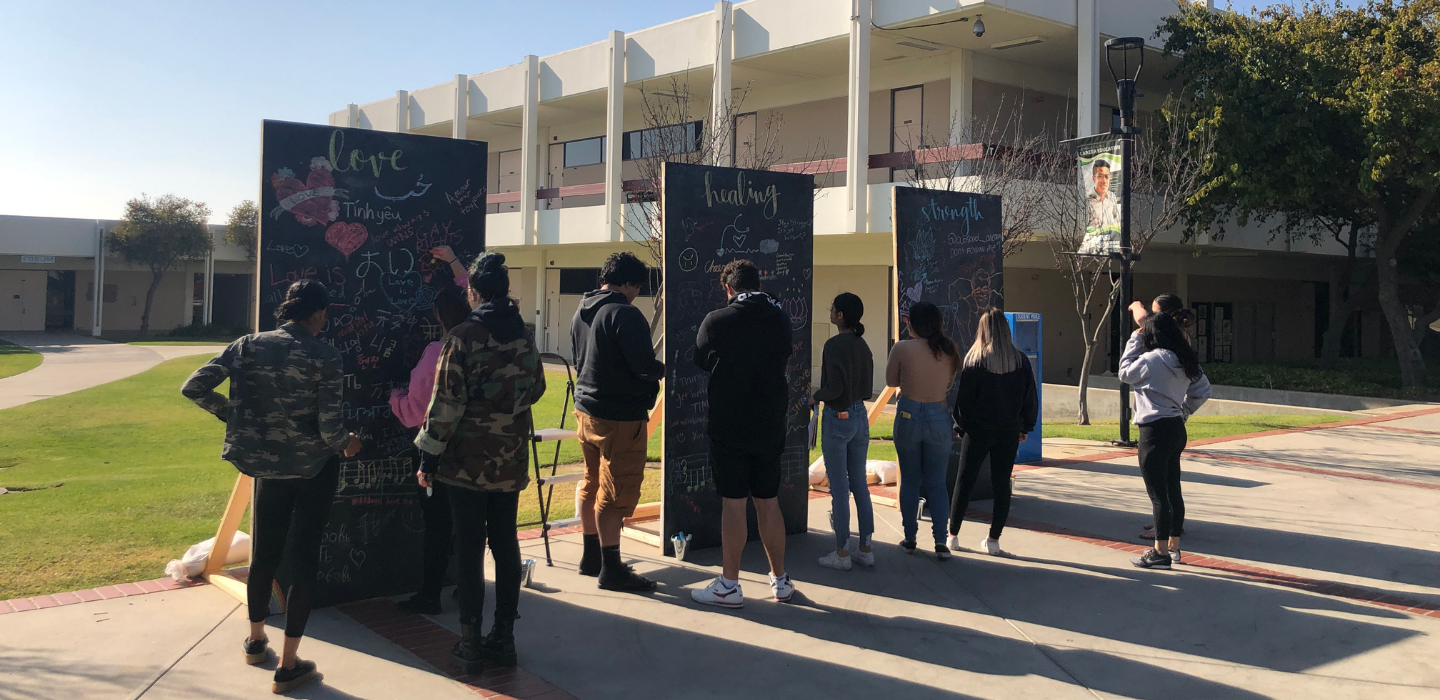 Students write on oversized chalk boards as part of the Healing Arts Festival
