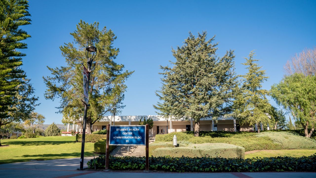 Photo of Student Health Center sign and office building from Raider Walk