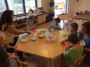 children eating snack with a teacher