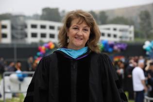 A faculty member poses for a photo at Commencement