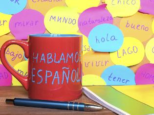 Post it notes and a coffee mug that have spanish words written on them.
