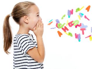 A small child holding their hands to their face and toy letters falling in front of them.