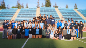 Moorpark College men’s and women’s track and field and cross country student-athletes pose with championship trophies on a stadium field