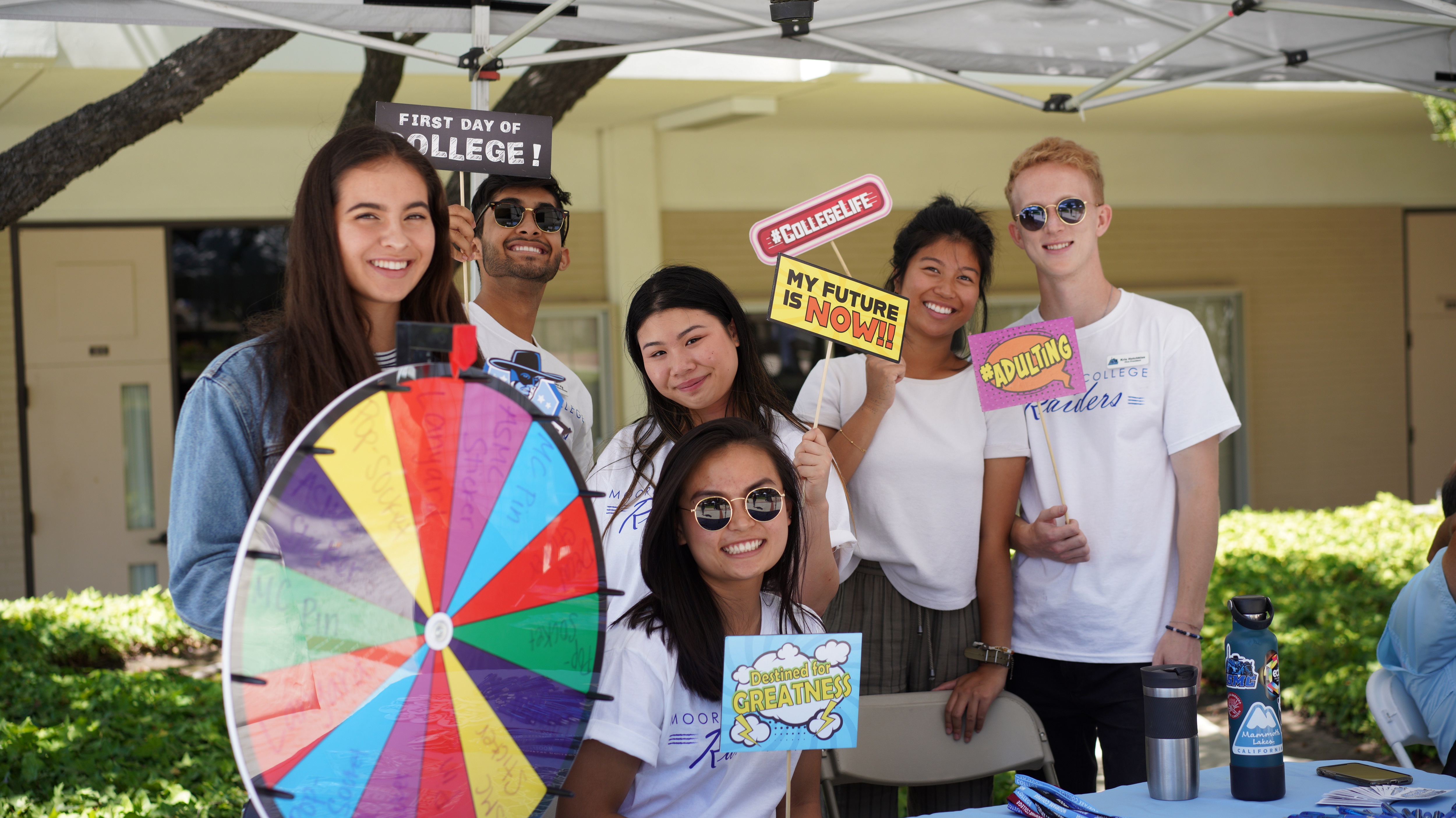 Students smile while hosting an interactive booth.