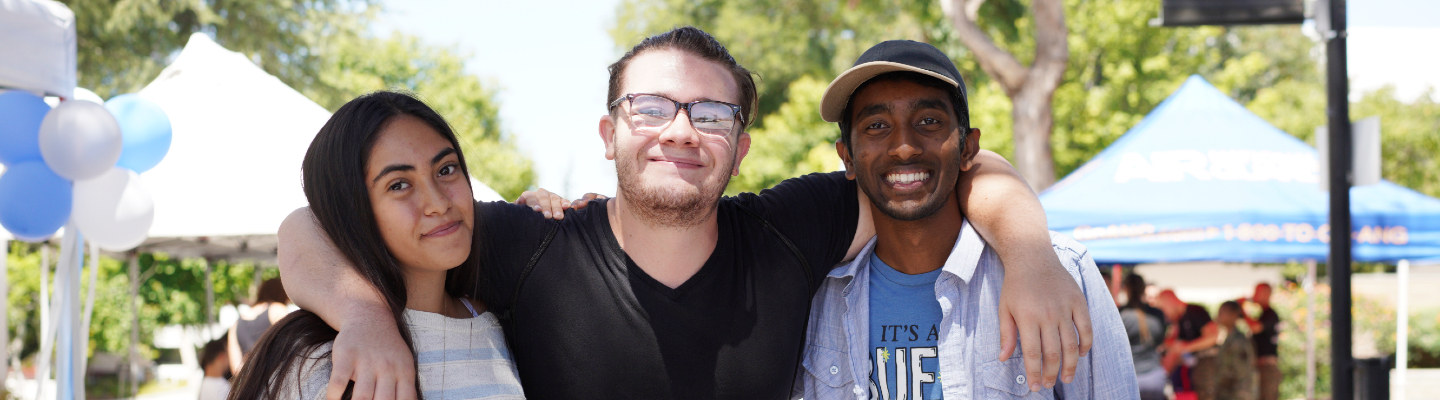 three students with arms around each other