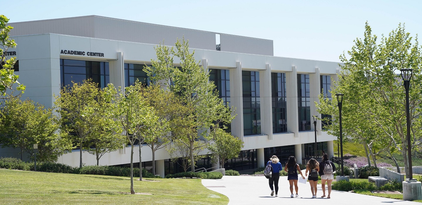 Students walk to the Academic Center building on campus.