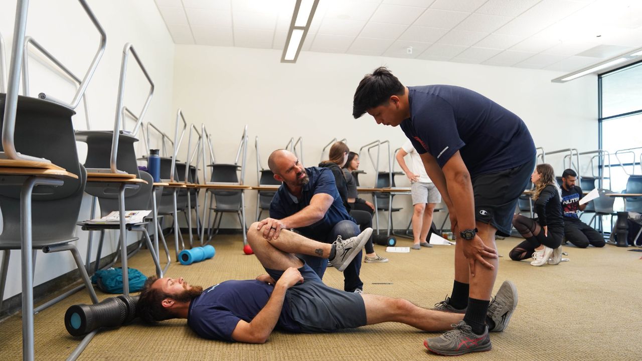 Professor doing a stretching demonstration in the Movement Analysis and Corrective Exercise Class