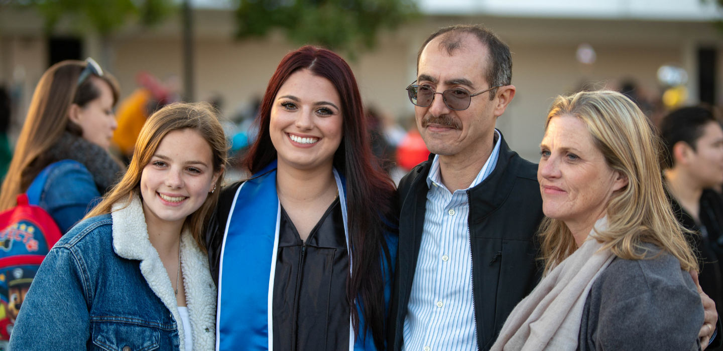 A family poses around their graduate at commencement.