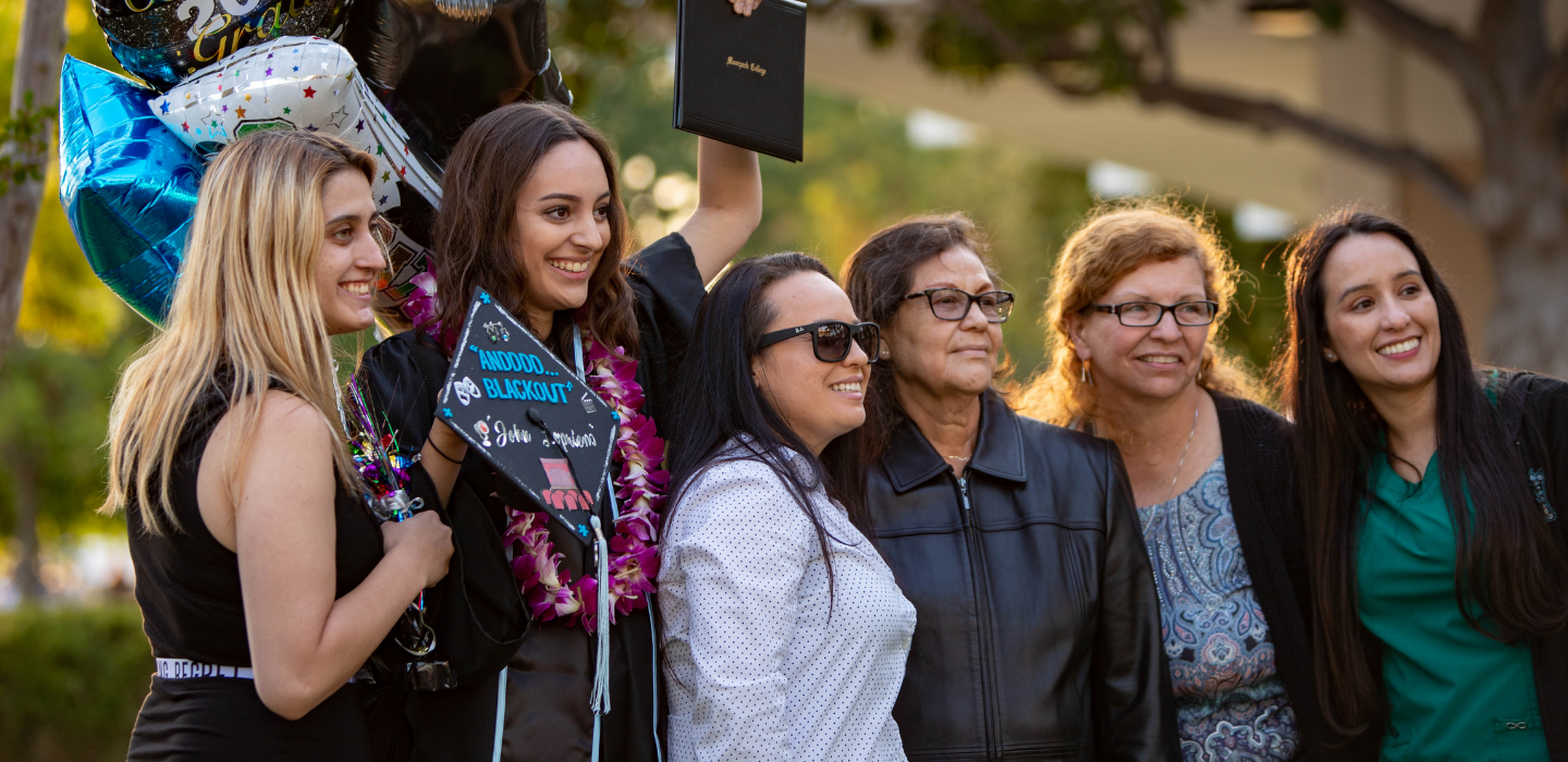A family poses around their graduate at commencement.