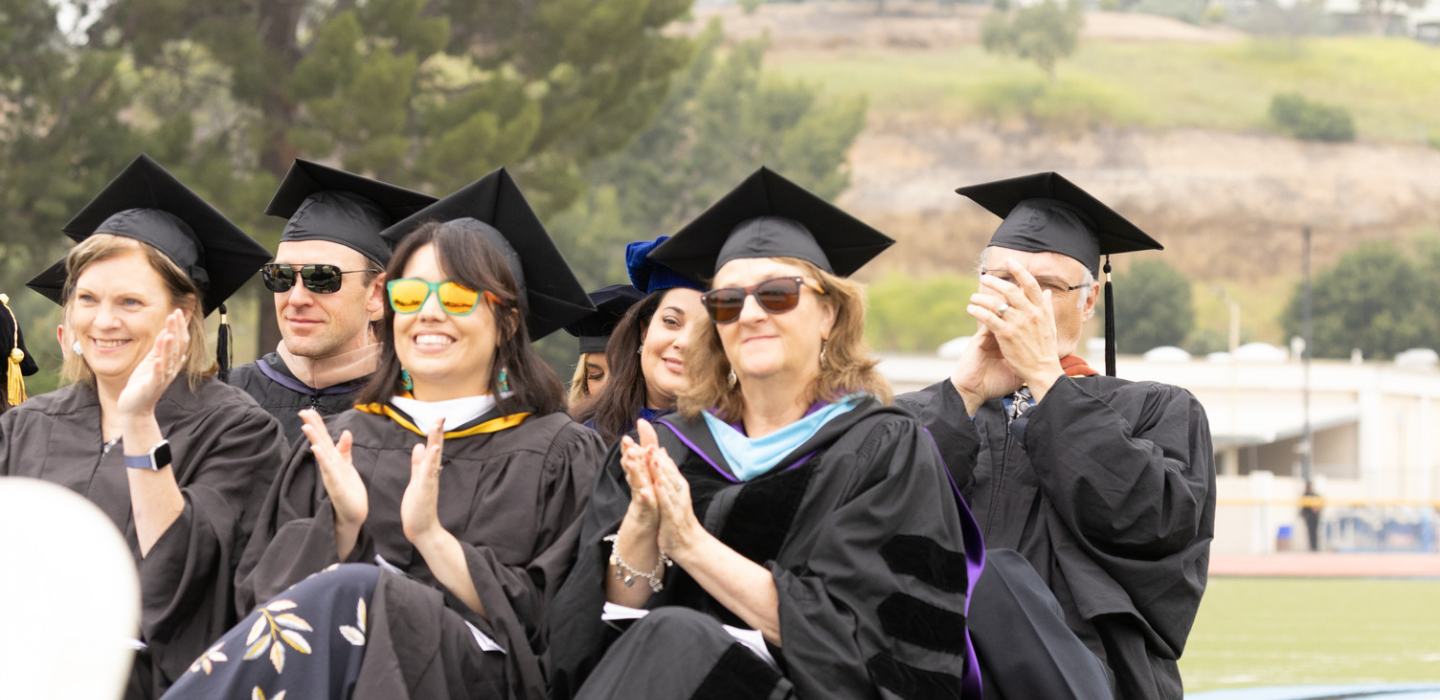 Faculty cheer on graduates during the 2023 Commencement.