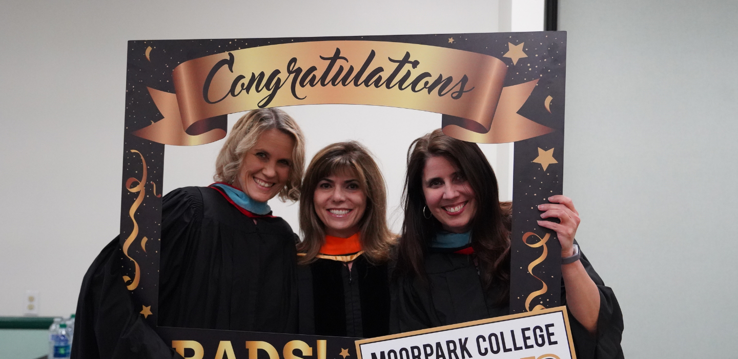 Faculty pose for a photo during a pre-Commencement gathering.