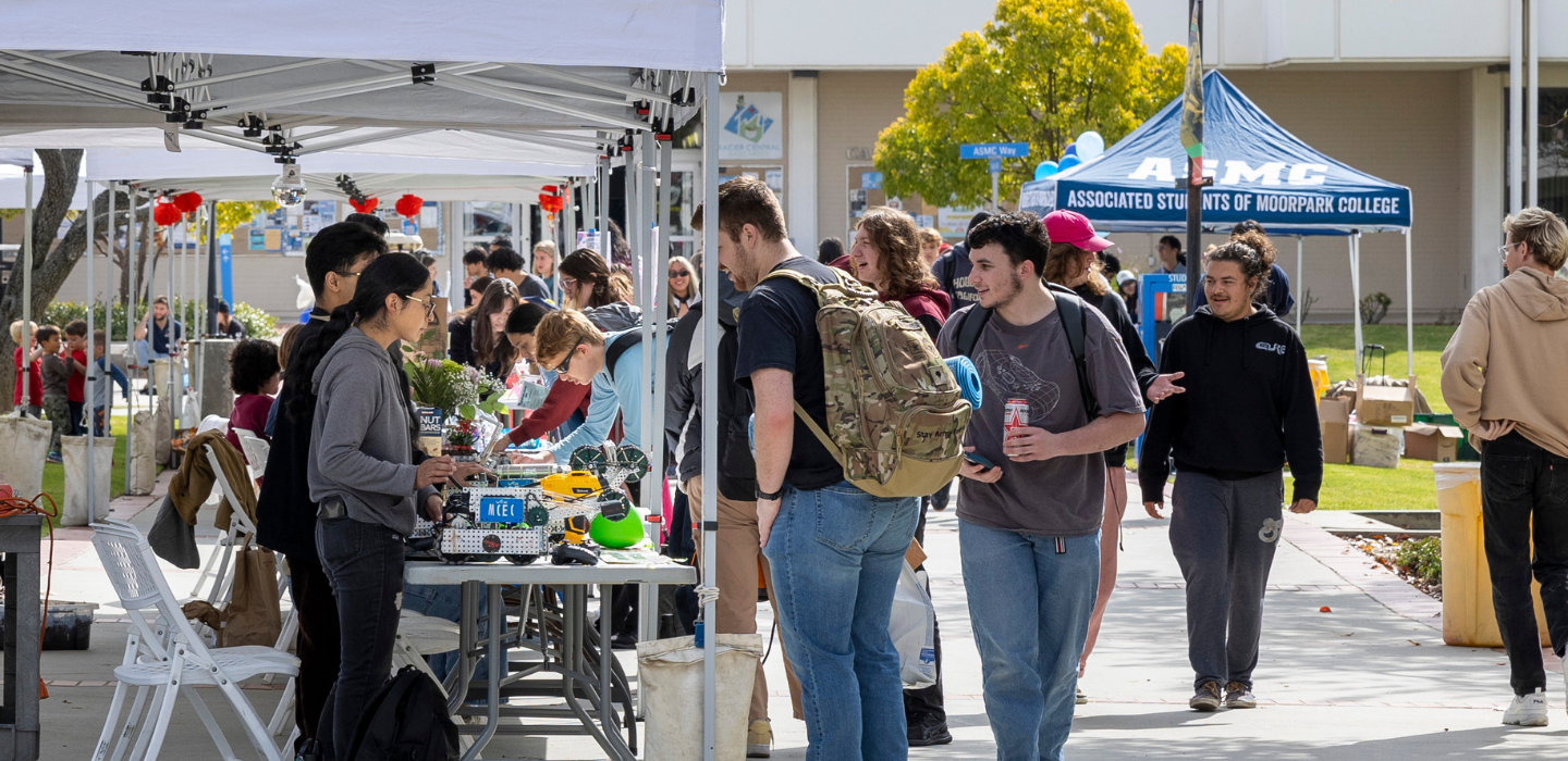 Crowd of people checking out material at tables for Club Rush
