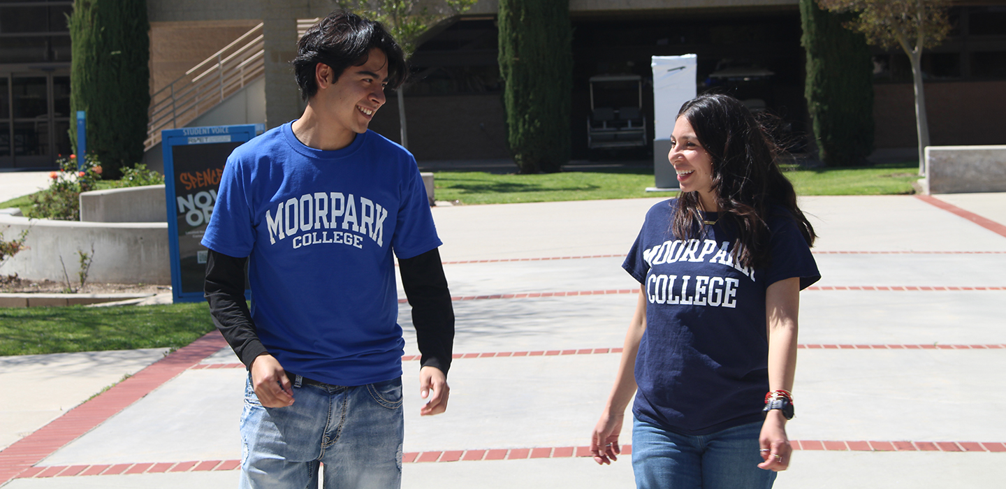 2 smiling students on campus