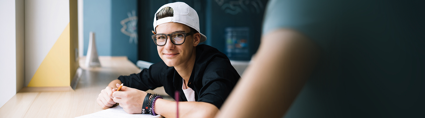 Young student looks at you while studying in math class