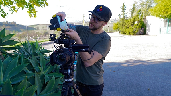 A man checking photography equipment for a shoot at the Moorpark College zoo..