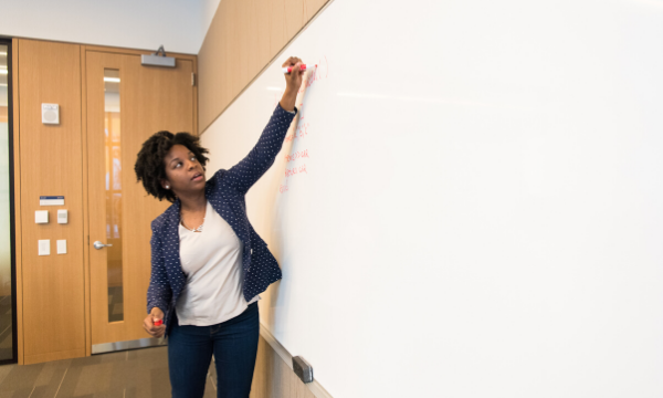 Professor writing on white board in a classroom