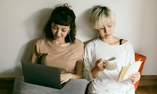 Two students sitting on the floor studying 