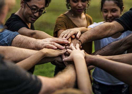 diverse group of people stacking hands