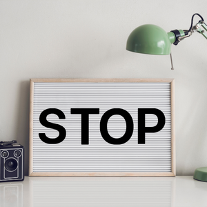 Letter board on desk with lamp that reads STOP