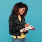 African American woman smiling while highlighting in a textb