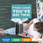 A student sitting on the floor of a library with a laptop an