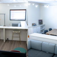 Inside the Campus Pride Center, computer stations, counter work spaces, tables for group collaboration, resources, and a couch