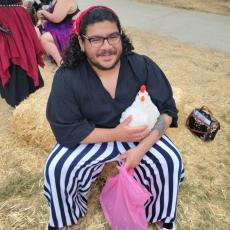 photo of Mauricio smiling and holding a fake chicken 