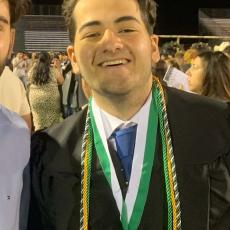picture of Adel smiling at his graduation 