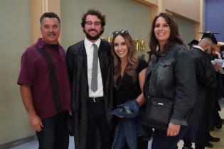 A family surrounds its graduate on commencement day.
