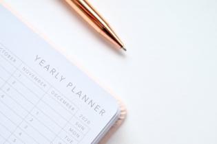 Yearly planner on a white table with metallic pen on top
