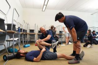 Professor doing a stretching demonstration in the Movement Analysis and Corrective Exercise Class