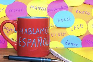 Post it notes and a coffee mug that have spanish words written on them.