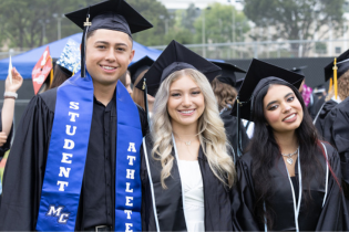 Three students smile for a photo together.