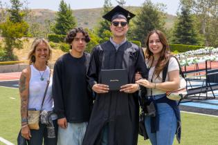 A family smiles as they pose for a photo with their family