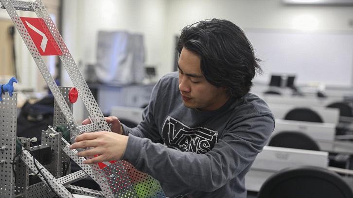 A member of the Engineering Club works on a robotic project.