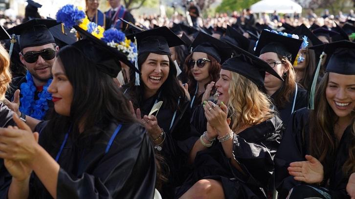 Students laugh and clap during the Commencement ceremony.