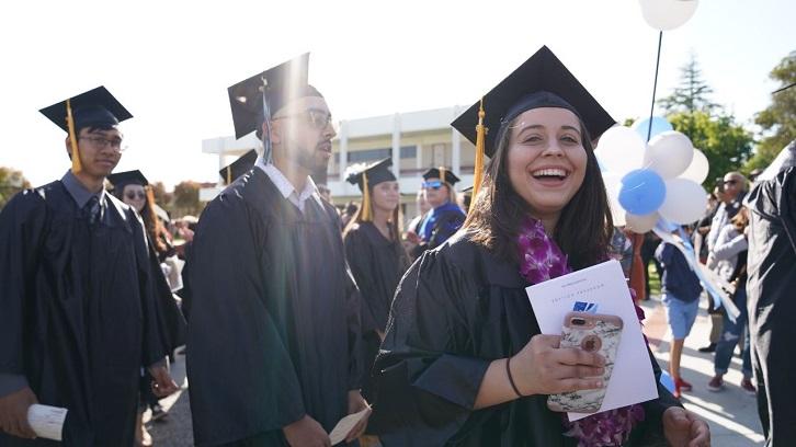 Students laugh and smile during the Commencement processional.