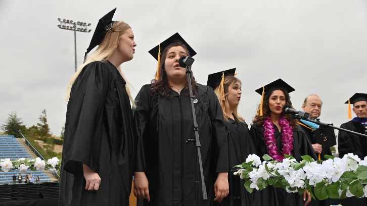 Four students sing the National Anthem at the beginning of Commencement.