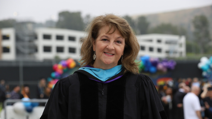 A faculty member poses for a photo at Commencement