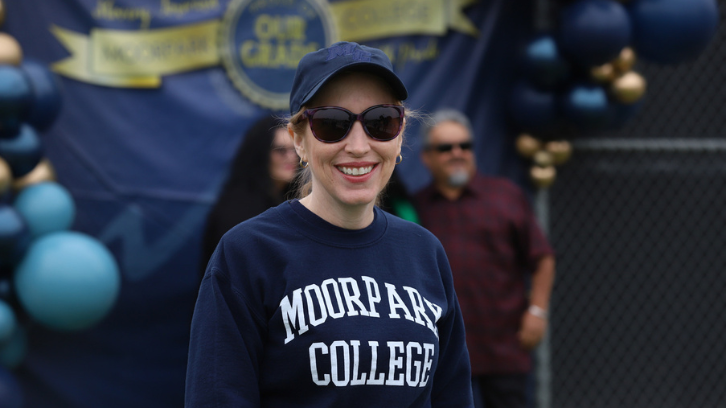 A staff member smiles while helping implement the Commencement ceremony.