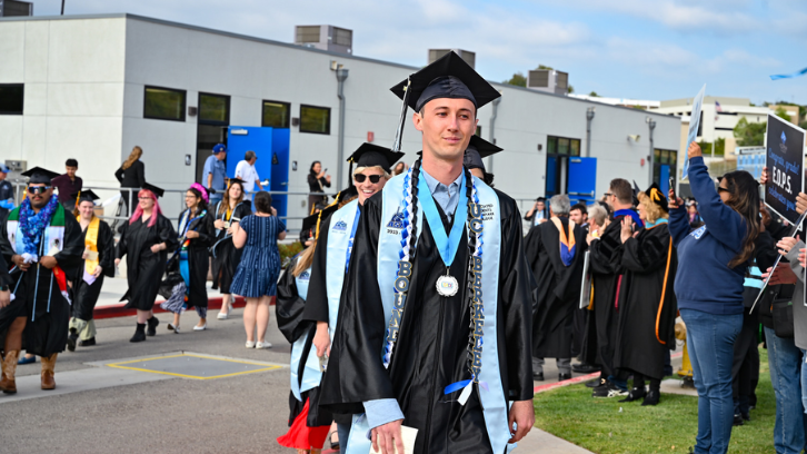 Student in cap and gown is leading line