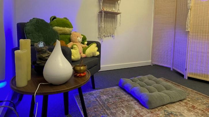 A diffuser, flameless candles, floor cushion, and sound bowl shown