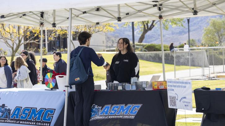 ASMC Director of Student Organizations Nora Barakat talks to a student during Club Rush 2024.