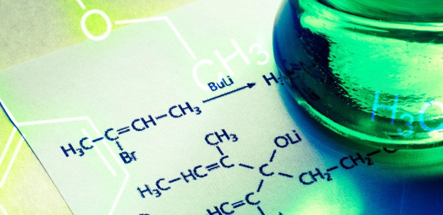 science formula on paper with beaker full of green liquid