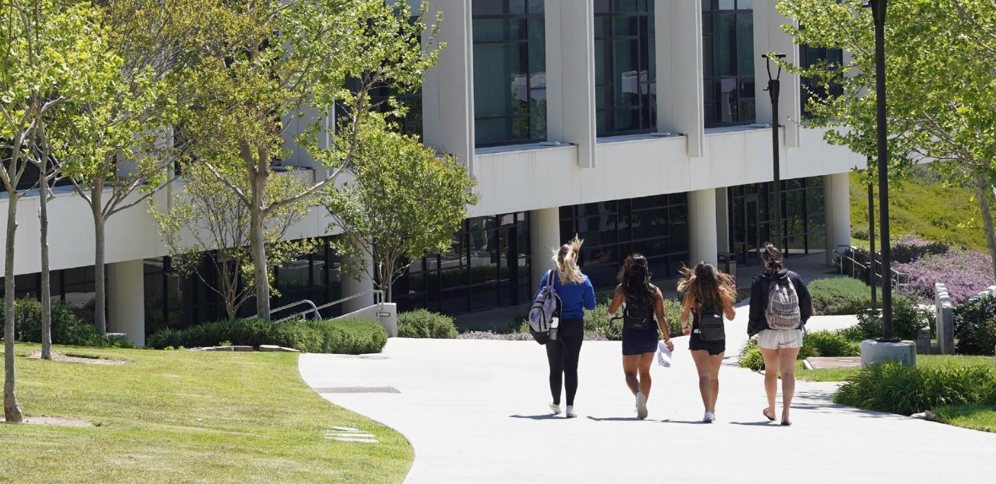 students walking past academic center building