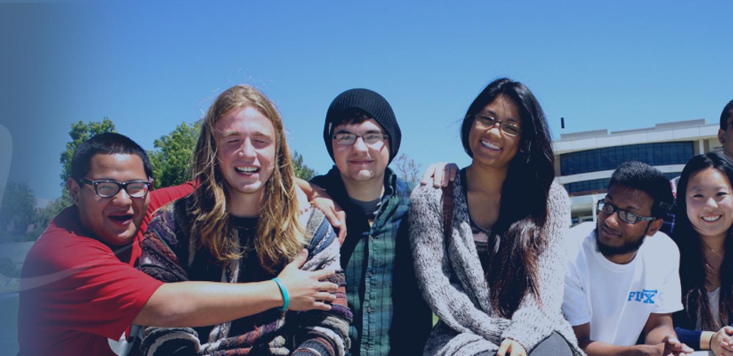 Group of young college students sitting on a wall at Moorpark College