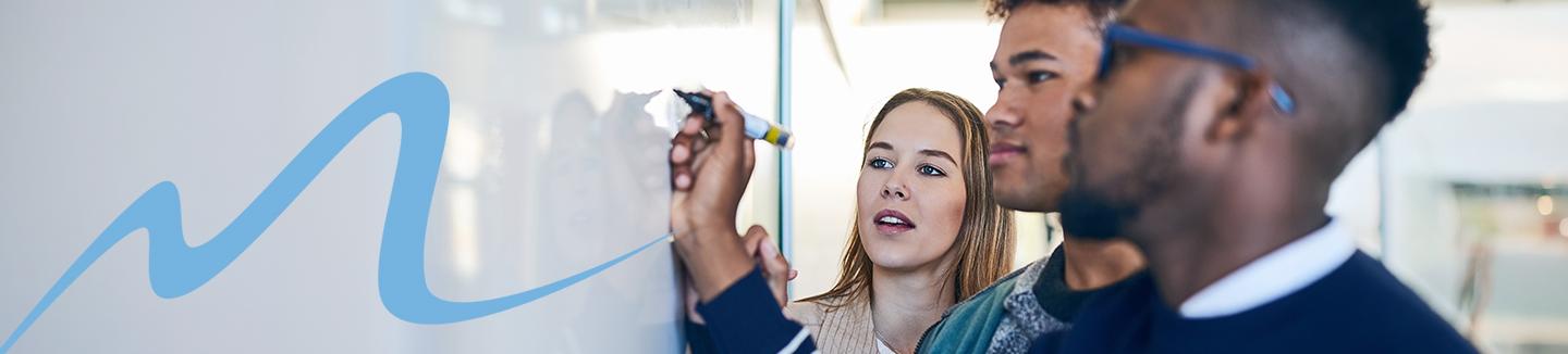 3 students practicing math on whiteboard