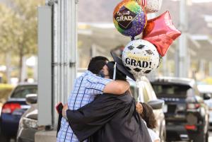 Moorpark College Graduate holding celebratory balloons and h
