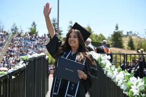 A graduate from Moorpark College wearing a cap and gown with A graduate from Moorpark College wearing a cap and gown with
